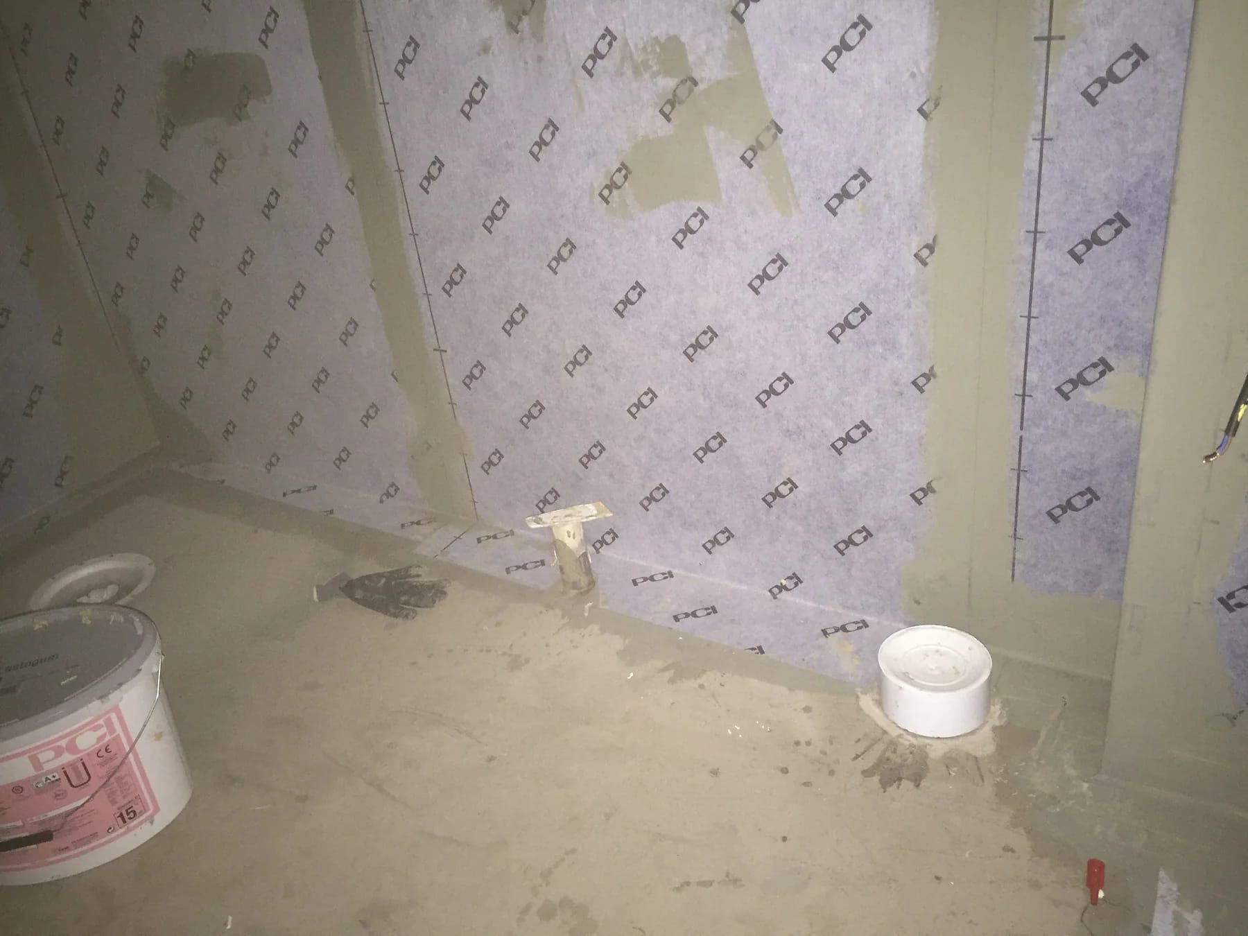 Tätskiktsduk uppsatt på väggarna i ett badrum under renovering