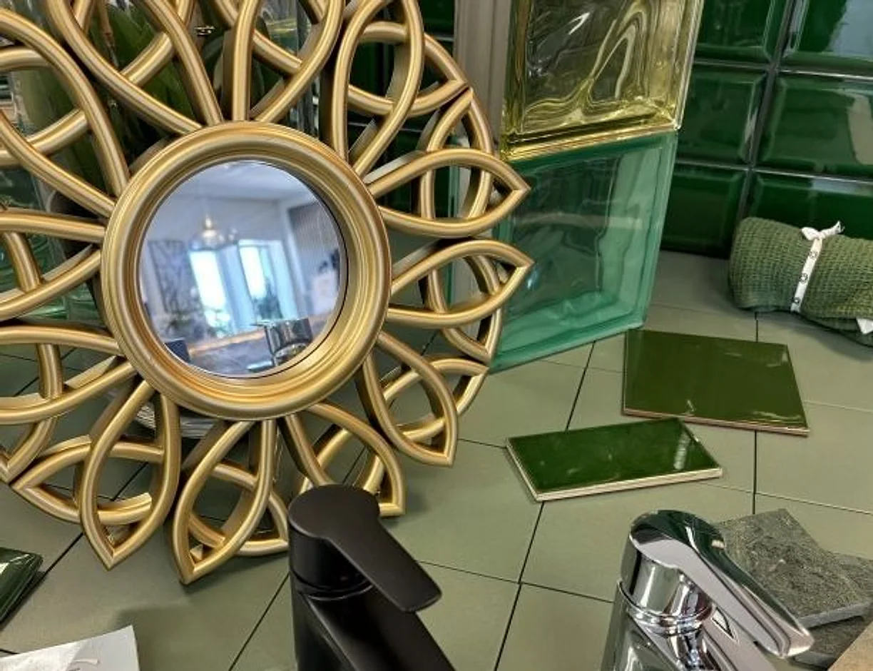 Speglar, blandare och gröna kakelplattor uppställda i butiken